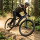 A rider navigating a winding dirt trail on a front suspension mountain bike.